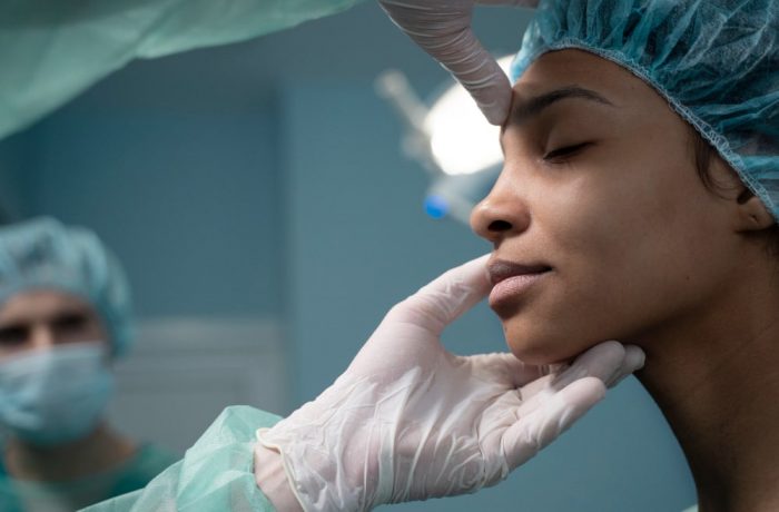 side-view-doctor-checking-patient-before-rhinoplasty-min